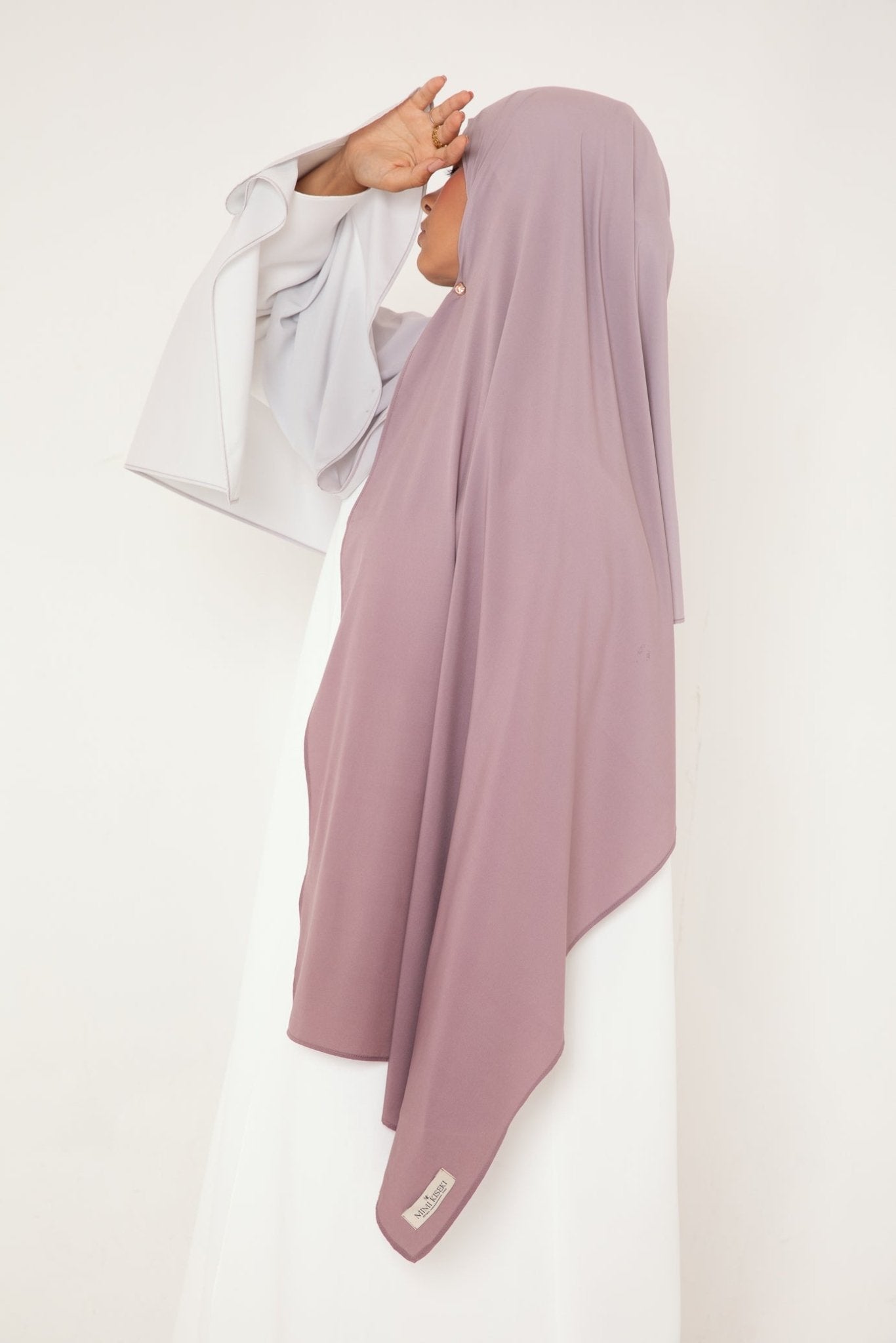 Femme de profil portant un hijab dégradé Mauve Doux de la collection Mimi Kiseki, illustrant l’élégance sobre et la fluidité d’un tissu premium, parfait pour une tenue modeste et raffinée.