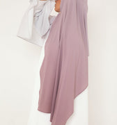 Femme de profil portant un hijab dégradé Mauve Doux de la collection Mimi Kiseki, illustrant l’élégance sobre et la fluidité d’un tissu premium, parfait pour une tenue modeste et raffinée.