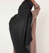 Vue arrière d’une femme portant le hijab en soie noire Mimi Kiseki – une pièce sophistiquée et sobre, conçue pour sublimer vos tenues avec dignité et prestance.